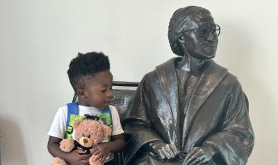 A child sitting with a statue
