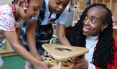 Carlyn Rahynes building blocks with children in a classroom
