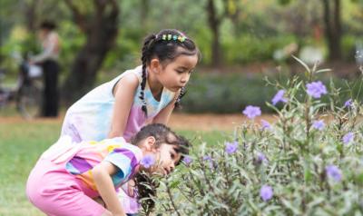 Two young children looking at a plant