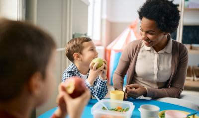 An educator and student eating lunch together