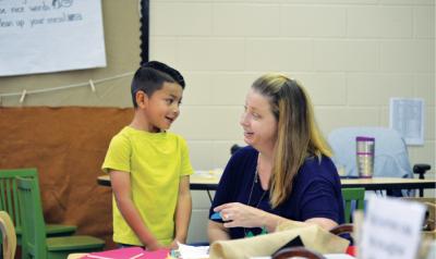Teacher and student working with materials