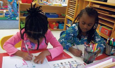 Two girls writing letters