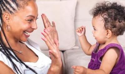 Toddler playing hand game with mother