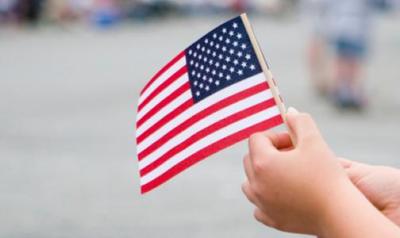 a child hand holding an american flag