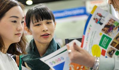 people looking at a catalog together at an event