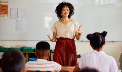 A teacher speaking at the front of the classroom