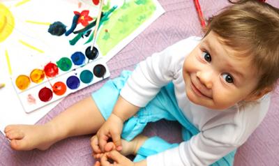 Toddler sitting next to a painting kit