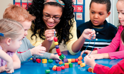 Teacher helping students build 