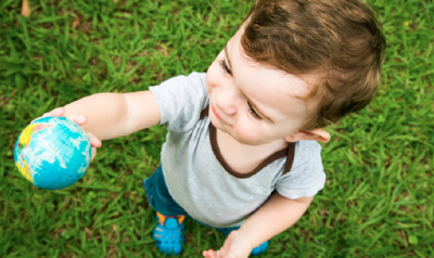 Toddler holding up a globe