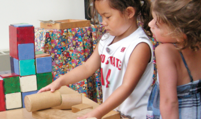 Two girls playing with blocks in classroom