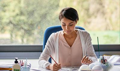 Early educator taking notes at her desk.