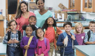 Two professionals posing with their students.