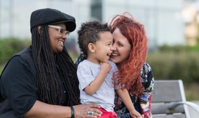 Two women interacting with a male toddler. 