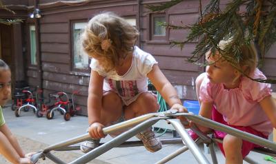 Three little girls playing together outside.