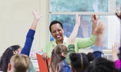 Teacher raising hand with students