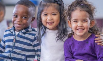 three children sitting and smiling 