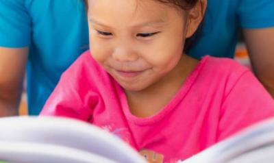 A young child reading a book.