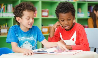 young children reading a book.