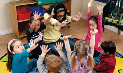 a group of students and a teacher raising their hands together