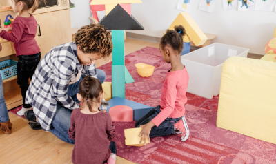 A teacher and students building with blocks.