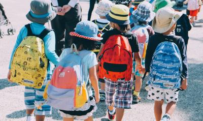 Children wearing backpacks head back to school.