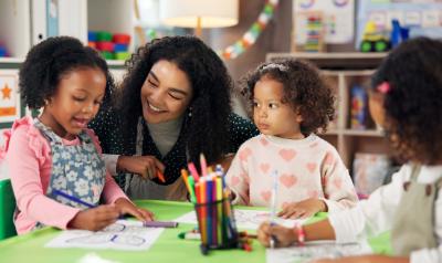 A teacher interacting with early childhood students in the classroom