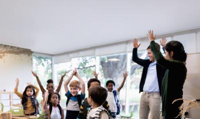 Teachers interacting with a group of students in the classroom