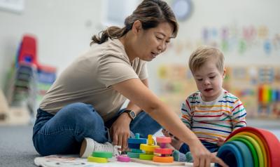 An early childhood educator teaching a child blocks