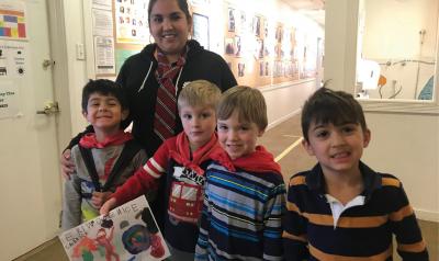Teacher and students smiling with artwork