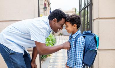 Father and son saying goodbye outside of school