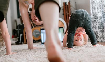 mother and two young girls doing yoga in the living room