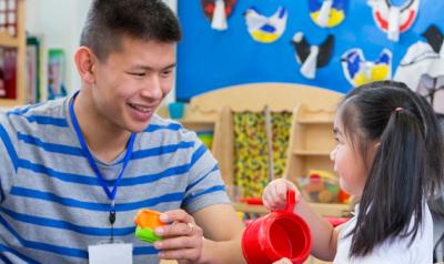 a teacher with a young child playing with toys