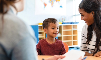 two adults talking with a young student