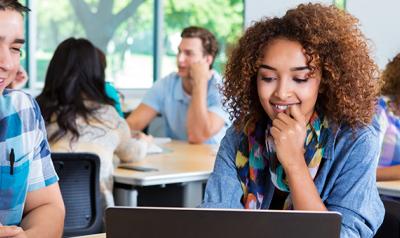 Adult student smiling at computer screen