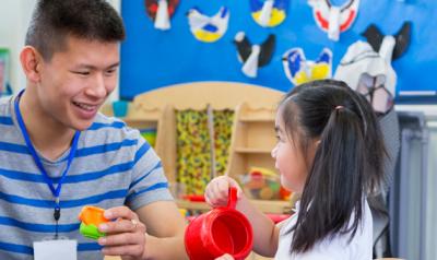 Teacher and young child interact in play.