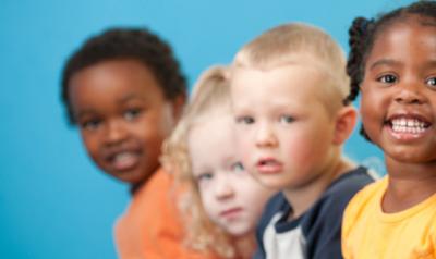 Five diverse children smiling at camera