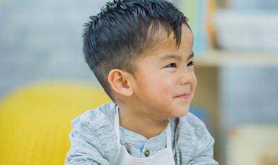 Two young boys at a table laughing