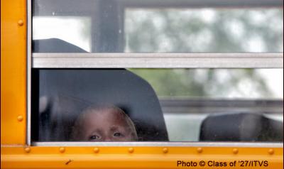 Little boy looking outside of school bus window
