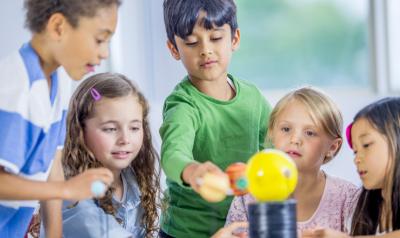 A small group of children conducts an experiment