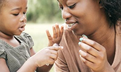 Young girl counting on her fingers with her mother.