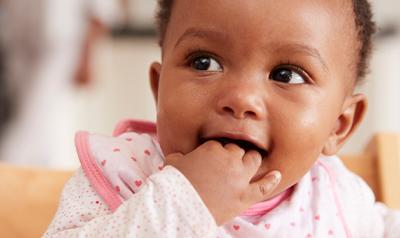 Baby girl chewing on her fingers