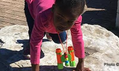 Young girl playing on rock outside