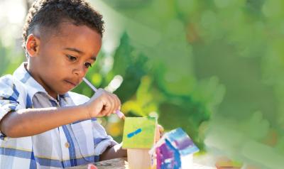 Child painting birdhouse