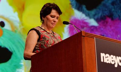 A presenter speaking from a podium at a conference