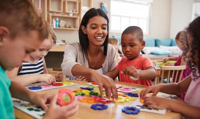 Teacher and diverse students at a table working with flower shapes