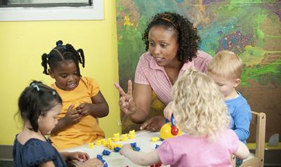 Teacher and children counting plastic bears.