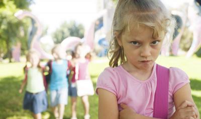 Unhappy girl with trio of girls behind her.