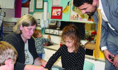 Two adults engage with children in a learning center