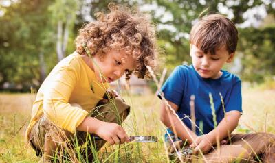 Children looking through magnetic glass in a field