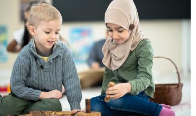 Two children playing on the floor in the classroom